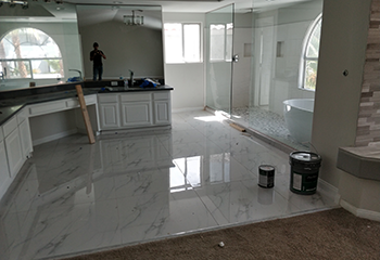 Luxurious master bathroom remodel in Redondo Beach featuring marble tiles and a freestanding bathtub.